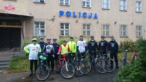 zdjęcie grupowe przed budynkiem policji w mragowie uczestnicy przy rowerach