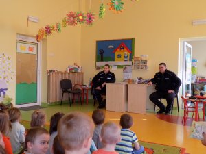 dwóch policjantów w sali, dzieci siedzą