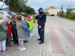 przy przejściu dla pieszych policjant rozmawia z dziećmi