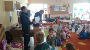 policjanci w przedszkolu prowadzą zajęcia, dzieci siedzą na podłodze