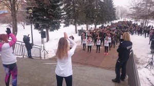 na placu unii europejskiej w mrągowie, grupka dziewczyn z koszulkami z napisem akcji tańczy na schodach a przed nimi tłum młodzieży