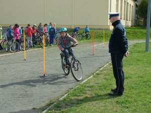 uczeń jedzie na rowerze pod nadzorem policjanta
