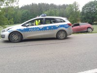 trasa Kosewo-Baranowo na pierwszym planie na ulicy  stoi radiowóz a za nim na poboczu bordowy ford focus