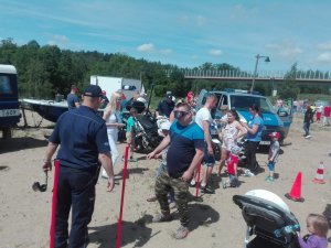 Festyn na Mrongoville, policjanci, prezentują sprzęt, radiowóz, uczestnicy chodzą w alkogoglach przez tor przeszkód