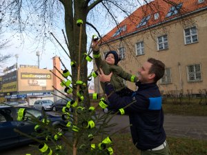 mężczyzna trzyma na ręku dziecko, które zawiesza odblask