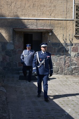 z budynku komendy wychodzi komendant wojewódzki policji w olsztynie a za nim komendant powiatowy policji w mrągowie