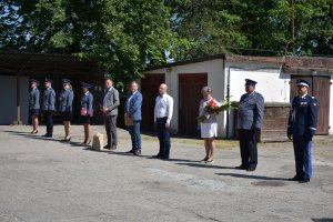 na parkingu za budynkiem policji, w odstępach stoją zaproszeni goście i kierownictwo policji