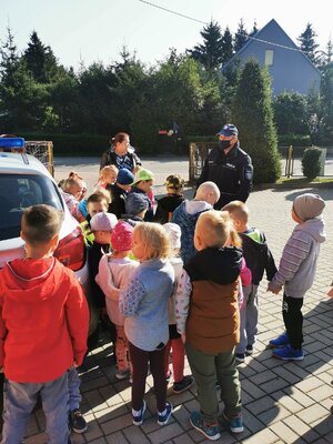 przy szkole policjant stoi wraz z dziećmi