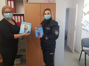 policjantka z panią dyrektor trzymają ksiązeczki
