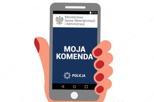 dłoń trzymająca telefon na telefonie napis &quot;Moja Komenda&quot;