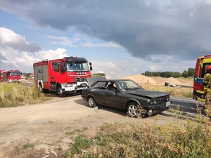 uszkodzony samochód i stojący za nim wóz strażacki