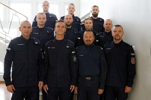 policjanci stojący na schodach. W pierwszym rzędzie drugi od lewej strony stoi mł.asp. Rafał Syczew, obok niego Komendat Wojewódzki Policji w Olsztynie nadinsp. Tomasz Klimek, w drugim rzędzie pierwszy od lewej strony stoi st.post. Paweł Łukaszuk, za nim stoi st.post. Paweł Sobczyński