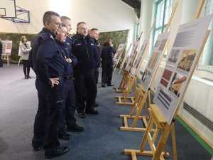 policjanci w sali stojący przed obrazami ustawionymi na sztalugach