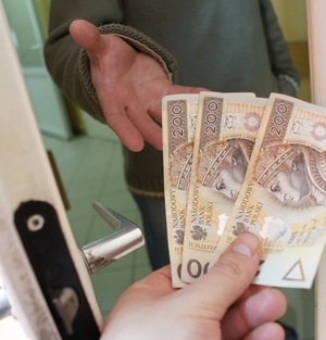 otwarte drzwi, wyciągnięta ręka i ręka przekazująca pieniądze