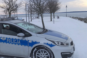 radiowóz policyjny na tle śniegu i jeziora