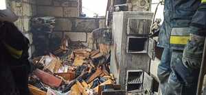 wnętrze budynku po pożaże z prawej strony piec i stojący przy nim strażak