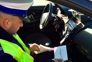 policjant ruchu drogowego wypisujący mandat karny