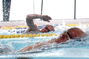 dwóch mężczyzn płynących w basenie z założonymi okularami do pływania na oczy