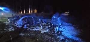 w nocnym świetle zgliszcza spalonych samochodów