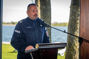 Przemawiający przy mównicy Komendant Wojewódzki Policji w Olsztynie nadinsp. Tomasz Klimek