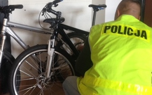 policjant klęczący przy rowerze