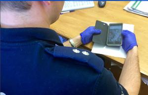 policjant w rękawiczkach lateksowych trzymający telefon