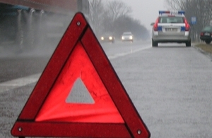 trójkąt ostrzegawczy na drodze a w tle radiowóz