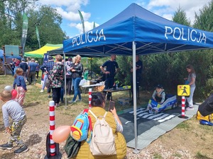 stoisko profilaktyczne policji z policjantami i uczestnikami pikniku rodzinnego