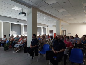 uczestnicy debaty siedzący na sali, z przodu siedzi Komendant Powiatowy Policji w Mrągowie oraz Naczelnik Wydziału Prewencji i Ruchu Drogowego