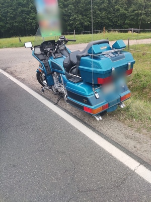 motocykl koloru niebieskiego stojący na poboczu