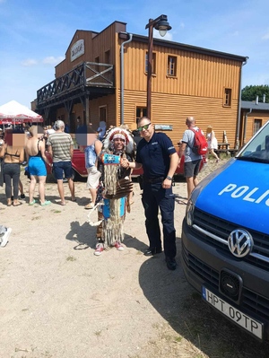 policjant stojący przy Indianinie w miasteczku westernowym