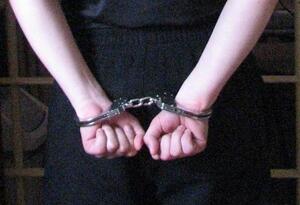 ręce trzymane z tyłu na których założone są kajdanki