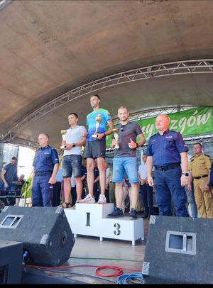 zawodnicy stojący na podium. Na trzecim miejscu st.post. Paweł Łukaszuk