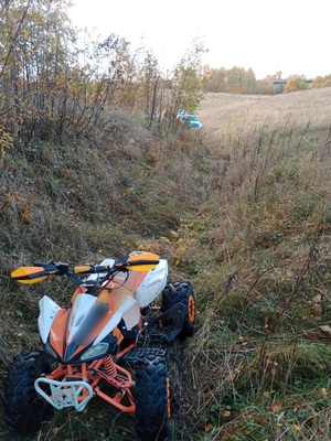 w polu quad stający na pierwszym planie w oddali widać radiowóz