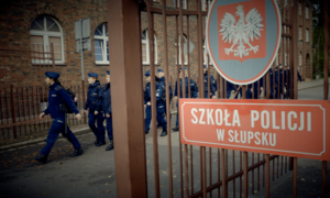 policjanci idący terenem szkoły policji i napis Szkoła Policji w Słupsku