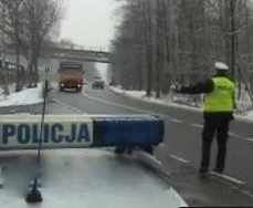 policjant ruchu drogowego zatrzymujący do kontroli pojazd ciężarowy