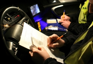 policjant ruchu drogowego wypisujący mandat