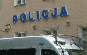 napis na budynku Komendy Powiatowej Policji w Mrągowie &quot;POLICJA&quot; i stojący przed budynkiem radiowóz