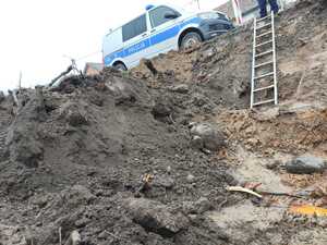 na drodze stoi radiowóz policyjny a na pierwszym planie wykopy