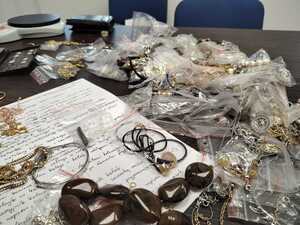 biżuteria która leży na stole, pod nią opisane kartki