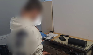 przy stole do daktyloskopowania stoi mężczyzna