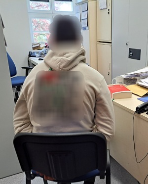 zatrzymany mężczyzna siedzi przy stole