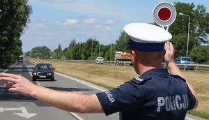 policjant ruchu drogowego zatrzymujący pojazd tarczą do zatrzymywania pojazdów