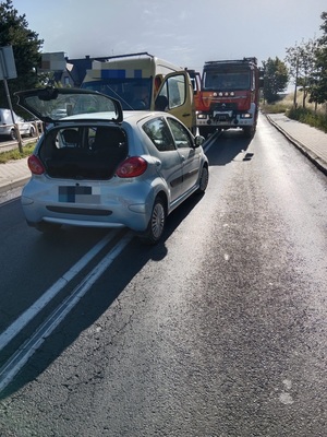 na drodze stoi pojazd osobowy, który przodem uderzył w busa. Obok nich stoi wóz strażacki