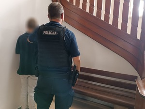 stoi policjant a przed nim zatrzymany mężczyzna