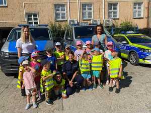 policjantka kuca przy stojących dzieciach