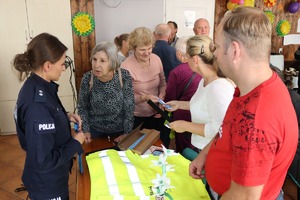 policjantka rozdaje elementy odblaskowe