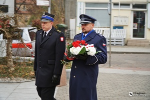 I Zastępca Komendanta Powiatowego Policji w Mrągowie kom. Michał Szynaka oraz Zastępca Komendanta Powiatowego Państwowej Straży Pożarnej w Mrągowie idą z kwiatami