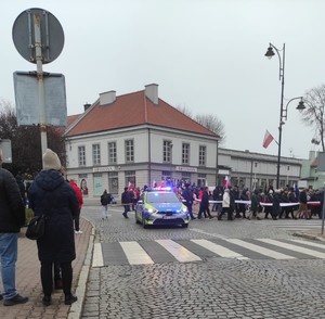 uczestnicy Marszu Niepodległości a przy nich stojący radiowóz