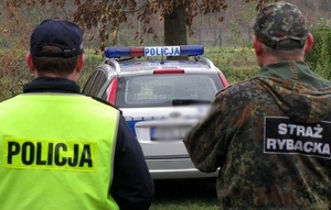 policjant i strażnik rybacki a w tle radiowóz